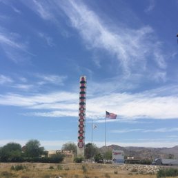 Towering 134 feet, The World's Tallest Thermometer with a backdrop of wispy clouds in the blue sky.