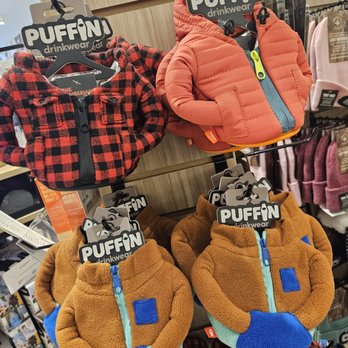 Uncharted - Kids' jackets and hats from Puffin drinkwear are arranged on a display rack in a retail store, featuring various colors and styles. - Accessories Near Me - Oak Brook, Illinois