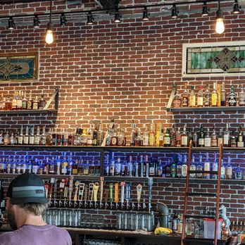The Whiskey Biscuit - a brick wall with shelves of liquor - New American Near Me - Englewood, Colorado The Whiskey Biscuit - a brick wall with shelves of liquor - New American Near Me - Englewood, Colorado