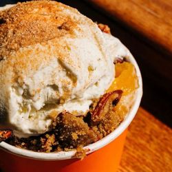 Peach Cobbler Factory-Stockbridge - Ripe, sweet peaches sit below a tender, flaky pie crust. Warmed to perfection then topped with homemade pralines.