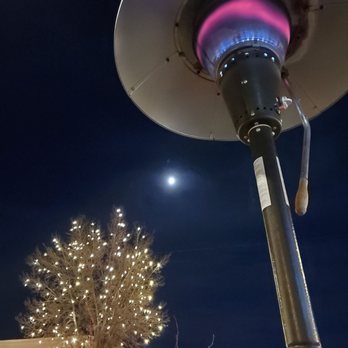 Bistro Nautile - a gas heater with a christmas tree in the background - French Near Me - Fort Collins, Colorado