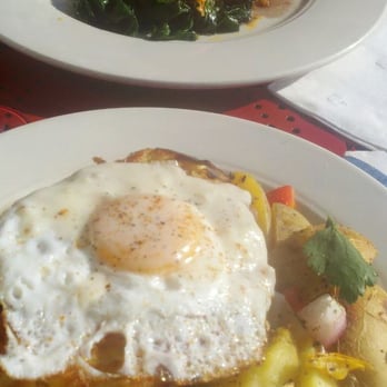 Le Petit Triangle Cafe - provencal sandwich topped with a sunny egg, and duck entree in background - French Near Me - Cleveland, Ohio