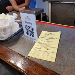 Phone shows the order I received, the QR code to the online menu and the yellow printed menu placed around the restaurant.