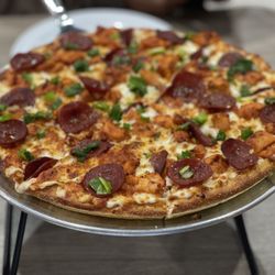 Pizza Twist - Hand tossed, white sauce, garlic, green onions, halal buffalo chicken, and halal pepperoni pizza.