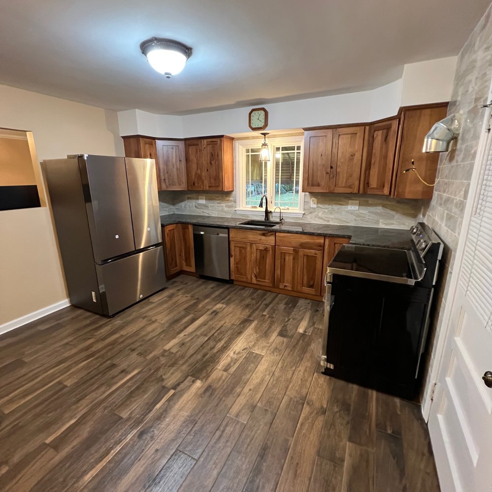 VB Renovations - a kitchen with wood flooring and stainless steel appliances - General Contractors Near Me VB Renovations - a kitchen with wood flooring and stainless steel appliances - General Contractors Near Me