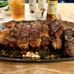 The 32oz ribeye comes out on a cast iron insert that's super hot on a wooden plate.