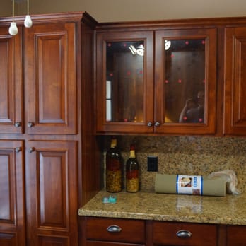 Shepherds Construction - a kitchen with wooden cabinets and granite countertops - General Contractors Near Me