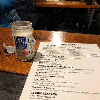 Aburaya - A menu and a jar of sake at a table in Aburaya - Izakaya Near Me - Oakland, California