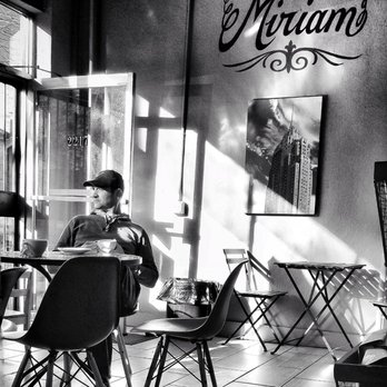 Café Miriam- City Park - A patron enjoys his Sunday morning coffee in a ray of golden sun flooding through the front windows of Café Miriam. - Coffee & Tea Near Me - Denver, Colorado