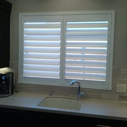 Shutter over kitchen sink with marble back-splash.