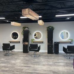 Elevation Hair Studio - Elevation Hair Studio interior -- Kingston, Ontario hair salon featuring three styling stations with backlit mirrors and crystal chandeliers