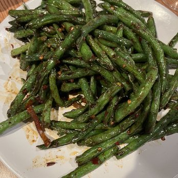 Spice 'n' Steam - House Special Sauce Green Beans - A white plate holds stir-fried green beans coated in a glossy sauce with chili flakes and garlic pieces. - Dim Sum Near Me - Eugene, Oregon