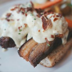 Bloom Restaurant + Bar - Kurobuta Pork Belly Benedict. Poached eggs over a rosemary focaccia muffin with crunchy ham bits sprinkled on top & a side of vegetables.
