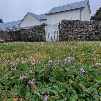 Twin Sisters Interior Design & Flooring - a stone wall and a stone fence with flowers in the foreground - Flooring Near Me - Boerne, Texas Twin Sisters Interior Design & Flooring - a stone wall and a stone fence with flowers in the foreground - Flooring Near Me - Boerne, Texas
