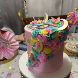 Pink buttercream w/ pipping design and purple butterflies & teal, yellow & pink frosting. Edible image & gold moon & star Pink buttercream w/ pipping design and purple butterflies & teal, yellow & pink frosting. Edible image & gold moon & star