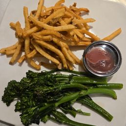 Sides of french fries and broccolini Sides of french fries and broccolini