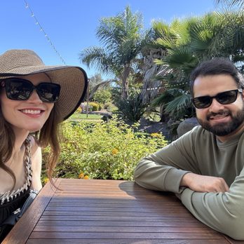 RD Winery - Myself and my husband at our table for a tasting. You will see they fixed up an outdoor area but it's right next to an industrial area. - Wine Tasting Room Near Me - Napa, California