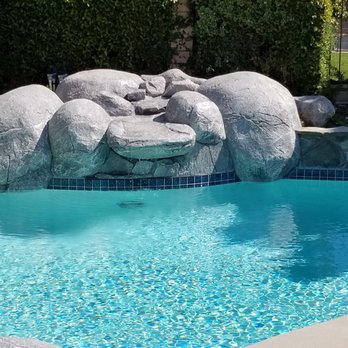 American Pebble & Tile - a pool with a waterfall - General Contractors Near Me - La Puente, California American Pebble & Tile - a pool with a waterfall - General Contractors Near Me - La Puente, California