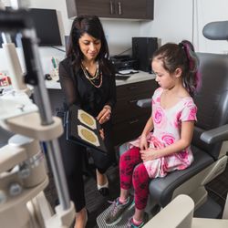 Photograph of an optometrist at Royal Oak Optometry educating a young patient about their eyes.