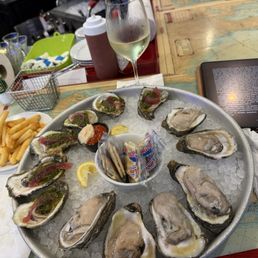 Raw oysters, oysters chimichurri, gluten-free French fries, and a delightful Sauvignon Blank. Raw oysters, oysters chimichurri, gluten-free French fries, and a delightful Sauvignon Blank.