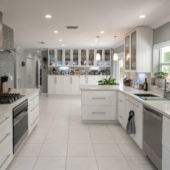 Unique Construction - Contemporary, open layout kitchen remodel with white cabinetry & quartz; highlighted by a mosaic glass tile accent wall & sleek range hood. - General Contractors Near Me - Miami, Florida