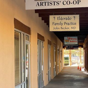 Artistic License Gallery - Artistic License Gallery in Agora shopping, Eldorado NM - The image shows a corridor with multiple glass doors, featuring signs for an art license gallery and a family practice clinic in Eldorado, NM. - Art Galleries Near Me - Santa Fe, New Mexico