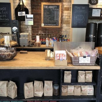 The Abbott - a coffee shop counter with coffee bags on it - Coffee & Tea Near Me - Toronto, Ontario