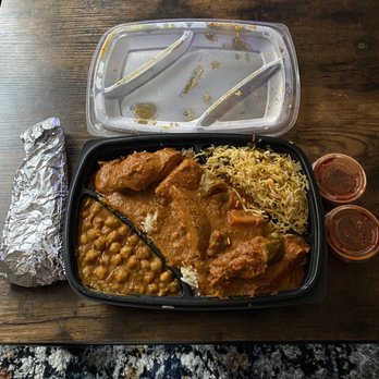 Butter Chicken Company 3 - Channa Masala (side) , Chicken Tikka Masala over a bed of pulao, Vegetable Biryani (side), Naan, and Vindaloo sauce on the side. - Indian Near Me - Washington, DC, District of Columbia