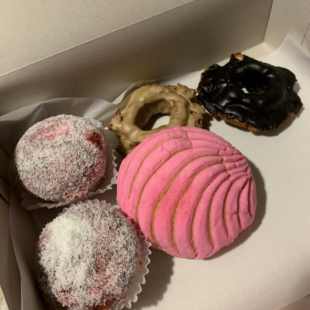 Donuts, concha and a strawberry jam/coconut flakes covered cake.