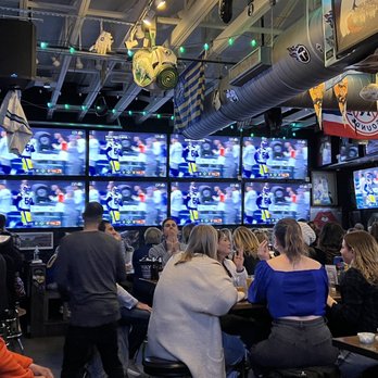 Neighbors - a group of people sitting at a bar watching televisions - Pubs Near Me - Nashville, Tennessee