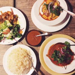 3 different curry dishes with a dish of rice.