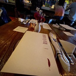 a restaurant table with menus and silverware a restaurant table with menus and silverware