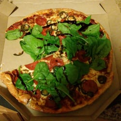 Pizza Hut - It is apparently their process to put spinach fresh on top of a cooked pizza!!!
