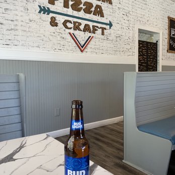 Calusa Pizza & Craft - a bottle of beer on a table - Pizza Near Me - Lutz, Florida Calusa Pizza & Craft - a bottle of beer on a table - Pizza Near Me - Lutz, Florida