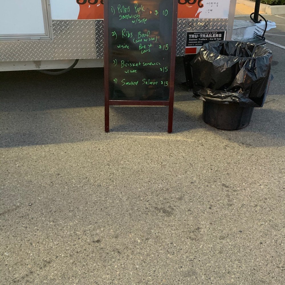Rollin Flame BBQ - a chalkboard sign and trash bags - Food Trucks Near Me Rollin Flame BBQ - a chalkboard sign and trash bags - Food Trucks Near Me