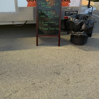 Rollin Flame BBQ - a chalkboard sign and trash bags - Food Trucks Near Me