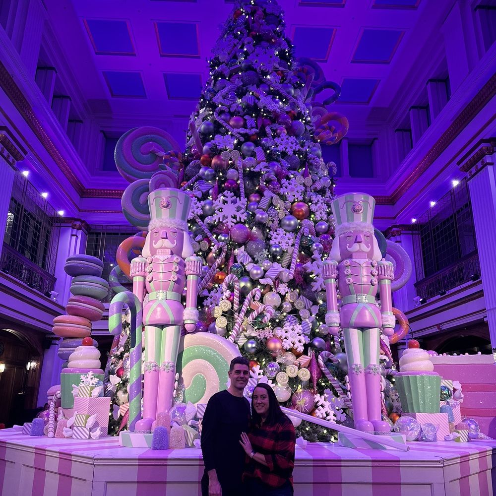 The Walnut Room - two people standing in front of a christmas tree - Pizza Near Me - Denver, Colorado