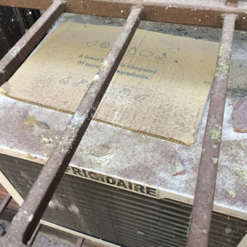 B Uddin Construction Company - Their idea of "covering" our A/C from the falling dust and debris. Yes, that is a chunk of fallen concrete. - General Contractors Near Me - Brooklyn, New York