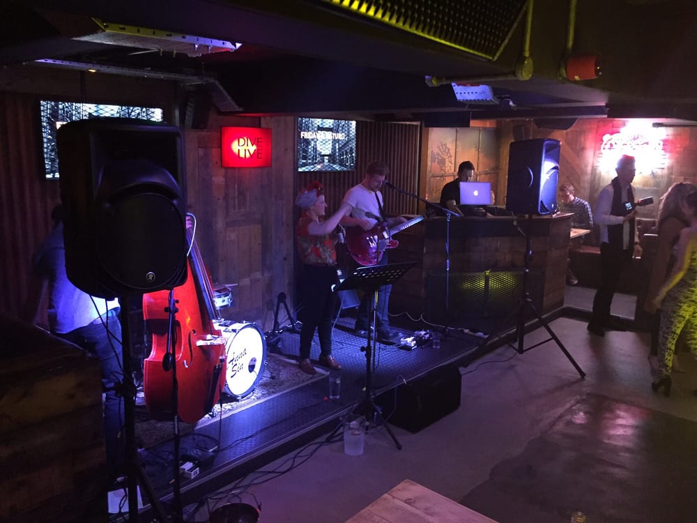 Dive NQ - Anna Sin playing in the band area - interior - Dive Bars Near Me - Manchester, XGM Dive NQ - Anna Sin playing in the band area - interior - Dive Bars Near Me - Manchester, XGM