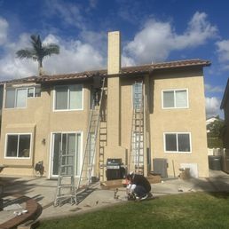 a man on a ladder in front of a house