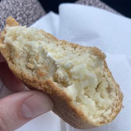 a hand holding a half eaten pastry