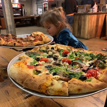 Cherokee Brewing and Pizza - a little girl looking at two pizzas - Pizza Near Me - Dalton, Georgia