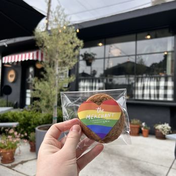 The Merchant - a person holding a cookie in front of a building - Coffee & Tea Near Me - Long Beach, California The Merchant - a person holding a cookie in front of a building - Coffee & Tea Near Me - Long Beach, California