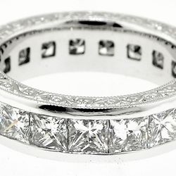 Princess cut diamond eternity band with hand engraving.