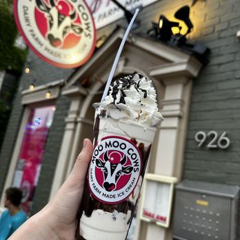 Moo Moo Cows - moo-fait - A milkshake topped with whipped cream and chocolate drizzle is held outside Moo Moo Cows ice cream shop in Baltimore, MD. - Ice Cream & Frozen Yogurt Near Me - Baltimore, Maryland