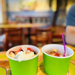 two cups of yogurt on a table two cups of yogurt on a table