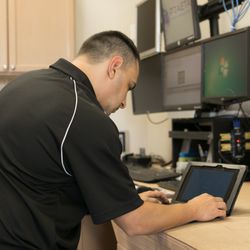 Anthony working on customer laptop in workshop