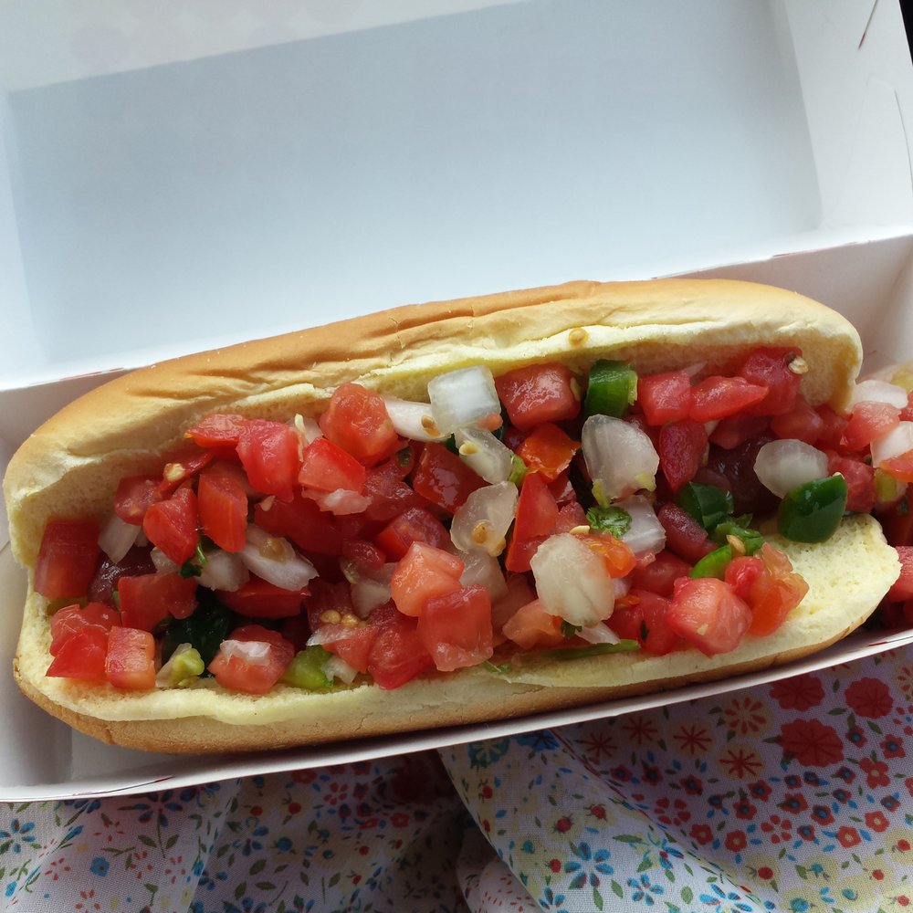 a hot dog with tomatoes and onions