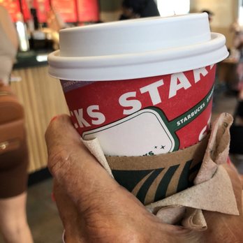Starbucks - a hand holding a cup of coffee - Coffee & Tea Near Me - Palm Beach Gardens, Florida Starbucks - a hand holding a cup of coffee - Coffee & Tea Near Me - Palm Beach Gardens, Florida