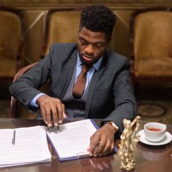 Maryland Neighborhood Notary - Professional young black man in the board room notarizing documents